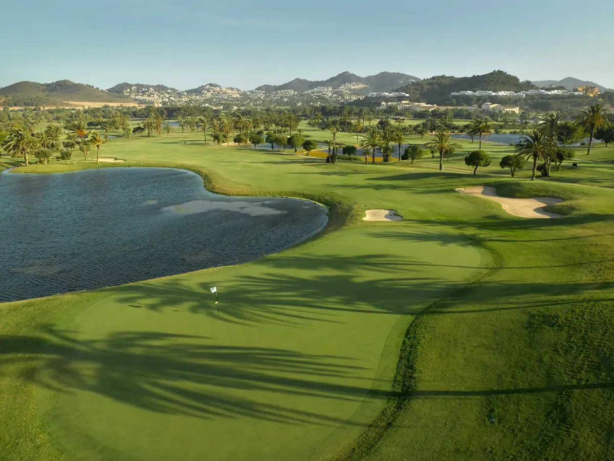 Fairway and lake at La Manga Club, with palm trees and the hills of Murcia behind